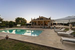 una piscina con patio y una casa en Villa Alike - IsulaTravel, en Módica