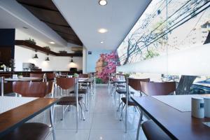 a restaurant with tables and chairs and a large window at Hotel LP Santa Cruz Centro in Santa Cruz de la Sierra
