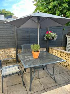 a black table with an umbrella and two chairs at The Millbrook B&B in Torquay