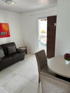 a living room with a couch and a table at Recanto do Sul - Campeche in Florianópolis