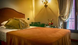 um quarto com uma cama, uma janela e uma cadeira em Hotel La Calcina em Veneza