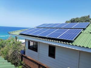 een huis met zonnepanelen op het dak bij 180° Ocean View Dune House in Chefe Imala