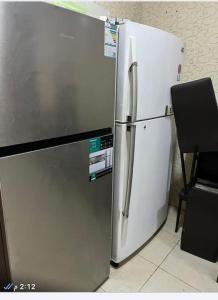 a white refrigerator in a kitchen next to a chair at شقة بجوار مسجد قباء in Al Madinah