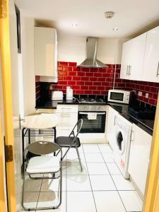 a kitchen with white cabinets and a washer and dryer at Excellent Two Bedroom Flat In Central London in London