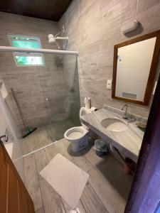 La salle de bains est pourvue d'un lavabo, de toilettes et d'un miroir. dans l'établissement Apartamentos de Juan, à Morro de São Paulo