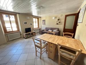 uma sala de estar com uma mesa de madeira e cadeiras em PRAETORIA 60 - Alloggio in Centro Storico - CIR Aosta n 0001 em Aosta