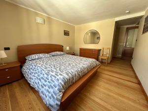 um quarto com uma cama, uma cómoda e um espelho em PRAETORIA 60 - Alloggio in Centro Storico - CIR Aosta n 0001 em Aosta