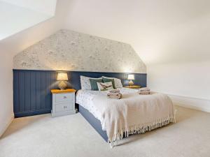 a bedroom with a blue and white bed and two lamps at 3 Bed in Glen Clova 75284 in Kirriemuir