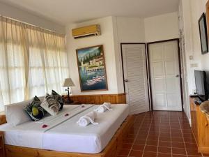 a bedroom with a large white bed with towels on it at Ekman Garden Resort in Sichon