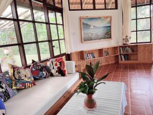 a living room with a couch and windows at Ekman Garden Resort in Sichon