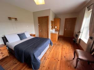 een slaapkamer met een bed en een houten vloer bij St Martin's, Rosslare Harbour Guest Accommodation in Rosslare