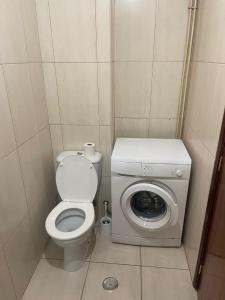 une petite salle de bains avec toilettes et lave-linge. dans l'établissement Picadeiro A, à Bragance