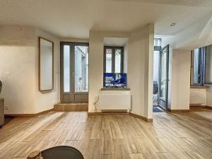 a living room with wooden floors and a flat screen tv at La terrasse des remparts - Sublime T3 in Carcassonne