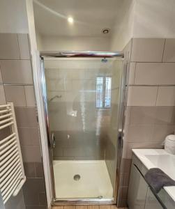 a shower with a glass door in a bathroom at La terrasse des remparts - Sublime T3 in Carcassonne +11 photos