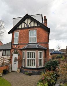 a large brick house with a white door at Lime Stays in Derby