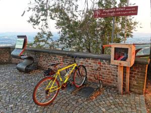 un vélo jaune garé à côté d'un mur de briques dans l'établissement Casa Laura, à Magliano Alfieri