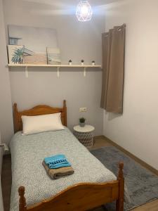 1 dormitorio con cama y estante con libros en Apartamento céntrico a 1km de la playa., en Puentedeume