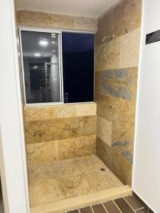 een badkamer met een douche en een raam bij El EmAnJe Sabaneta in Sabaneta