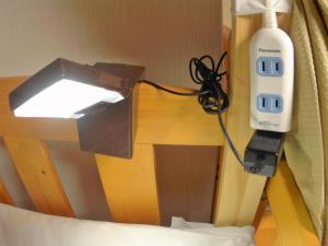 a hair dryer is attached to a bed with a light at Guest House Ga-Jyun in Kyoto