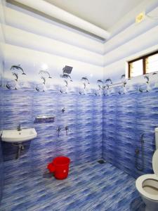 Baño azul con lavabo y aseo en TROPICAL STORIES, en Varkala