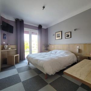 a bedroom with a large bed and a checkered floor at Hotel Bar Tabac Point Chaud L'Ecureuil in Saint-Paul-en-Born