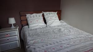 a bed with white sheets and pillows next to a dresser at Studio tout confort à 5 mn métro+parking gratuit in Montreuil