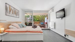 - une chambre avec un grand lit et une télévision à écran plat dans l'établissement Casa Laura -PARKING - POOL, à Saint-Tropez
