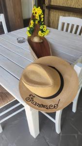 un chapeau de paille assis sur une table avec des fleurs dans l'établissement La Fattoria Dei Nonni, à Paterno