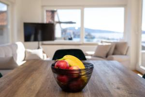 un cesto di frutta seduto su un tavolo di legno di 4 Seasons Rogoznica - Apartment a Rogoznica (Rogosnizza)