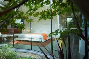 ein Schlafzimmer mit einem Bett in einem Glaszimmer in der Unterkunft MAISON RONAN KERVARREC - Rennes - Saint-Grégoire in Saint-Grégoire