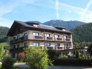 un gran edificio de apartamentos con balcones y montañas en el fondo en Haus Schweighofer en Neuberg an der Mürz