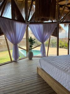 a bedroom with purple curtains and a bed in a room at JERUSALEMA BEACH GLAMPING in Tolú