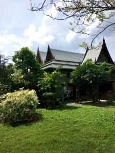 una casa con techo y patio en MrT Riverside Sampran มิสเตอร์ที โฮมสเตย์-การเวก, en Sam Phran