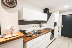 a kitchen with white cabinets and a sink at Suit'Home Commerce in Angers +12 photos