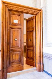 uma porta de madeira num quarto com uma janela em La Torre Rooms em Spoleto