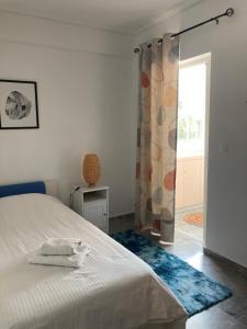 1 dormitorio con cama blanca y ventana en Mimoza's Apartment, en Atenas