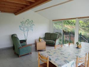 a living room with a table and chairs at Maison de campagne in Le Lude