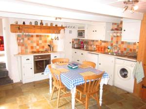 a kitchen with a table and chairs in it at Jowders Cottage in Marazion