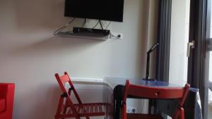 a room with a desk and a tv on a wall at Studio tout confort à 5 mn métro+parking gratuit in Montreuil