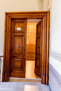 una puerta de madera abierta en una habitación con escaleras en La Torre Rooms, en Spoleto