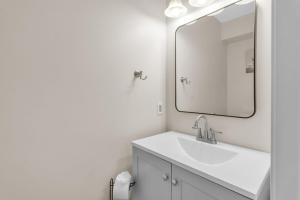 a bathroom with a sink and a large mirror at Central Downtown Living in Buffalo +14 photos