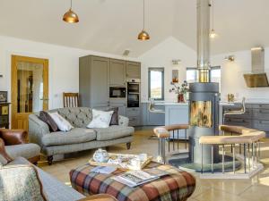 a living room with a couch and a fireplace at 4 Bed in The Cairngorms 80298 in Knockandhu