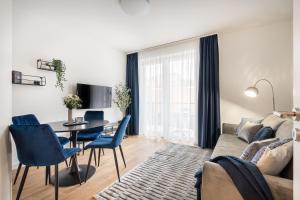 a living room with a couch and a table and chairs at Rose Garden Residence - Boutique Apartments in City Center in Budapest