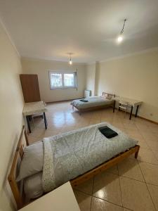 Habitación con 2 camas y mesa. en Apartamento na Rua José Reboredo, en Bragança