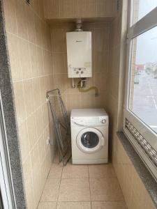 baño con lavadora y ventana en Apartamento na Rua José Reboredo, en Bragança