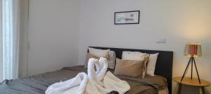 a bed with a pair of towels on it at Ria Palace Apartment in Aveiro