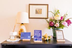 a table with a lamp and a vase of flowers at La Torre Rooms in Spoleto
