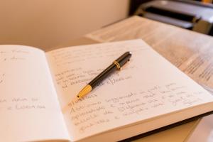 a pen sitting on top of a notebook on a table at La Torre Rooms in Spoleto