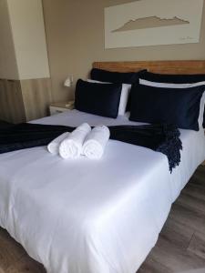 two towels on top of a large white bed at Menlyn Maine Trilogy Apartment 1010 in Pretoria