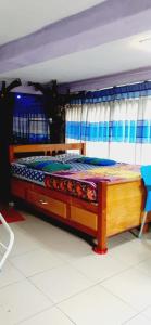 1 cama con marco de madera en una habitación en Home Stay Nawalapitiya en Nawalapitiya